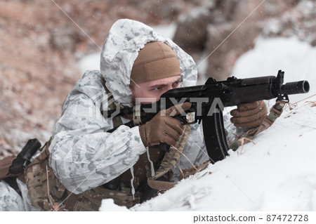 Soldier in winter camouflaged uniform in Modern warfare army on a snow day on forest battlefield with a rifle. Model face very similar to Ukraine prime minister. Soldier in winter camouflaged uniform in Modern warfare army on a snow day on forest battlefield with a rifle. Model face very similar to Ukraine prime minister. 87472728
