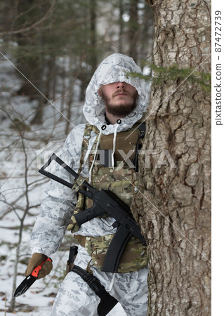 Soldier in winter camouflaged uniform in Modern warfare army on a snow day on forest battlefield with a rifle. Model face very similar to Ukraine prime minister. Soldier in winter camouflaged uniform in Modern warfare army on a snow day on forest battlefield with a rifle. Model face very similar to Ukraine prime minister. 87472739