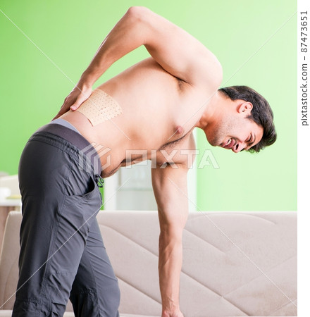 Man applying pepper Capsicum plaster to relieve pain 87473651
