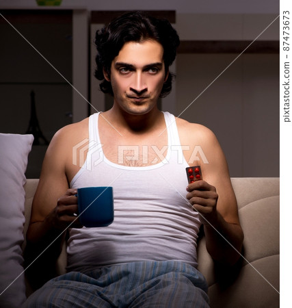 The young man suffering at home night time 87473673