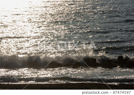 Waves shining reflecting the sunset 87474597