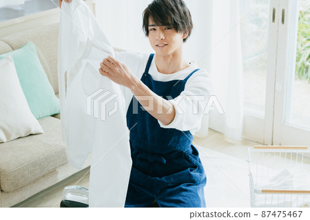 Young man ironing Young man ironing 87475467