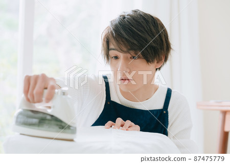Young man ironing 87475779