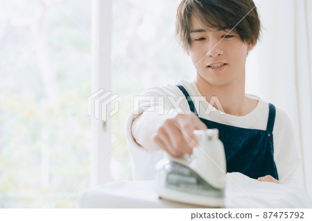 Young man ironing Young man ironing 87475792