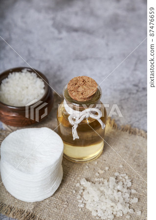 Glass bottle with lotion, sea salt body scrub and cotton pads for skin beauty care. Natural homemade cosmetic product, essential oil Glass bottle with lotion, sea salt body scrub and cotton pads for skin beauty care. Natural homemade cosmetic product, essential oil 87476659