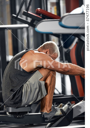 Training legs in the simulator, the athlete works with his legs on the simulator, working out the muscles on the legs Training legs in the simulator, the athlete works with his legs on the simulator, working out the muscles on the legs 87477196