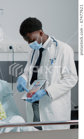 Medic explaining cardiovascular figure on digital tablet Medic explaining cardiovascular figure on digital tablet 87477621