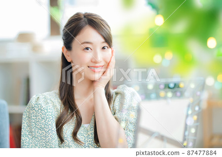 一個微笑的年輕女人，在客廳裡照鏡子時關心自己的皮膚 87477884