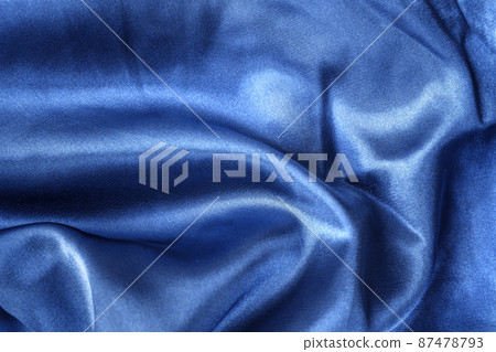 Elegant smooth blue silk or satin folds closeup. Cloth texture background. Abstract wallpaper. Trendy dark skyblue backdrop for web design. Luxury twisted fabric backplate  87478793