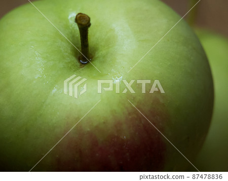 A large green apple, a close-up shot. A wet apple. 87478836