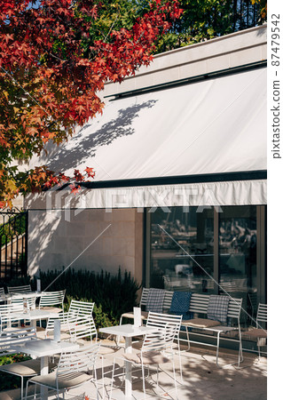 Tables and chairs are on the tiles outside the restaurant. Porto. Montenegro 87479542