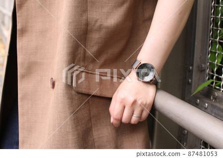 A woman's arm with a wedding ring and a wristwatch A woman's arm with a wedding ring and a wristwatch 87481053