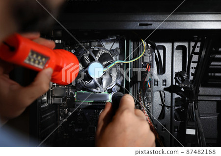 Man with flashlight fixing system unit indoors, closeup 87482168