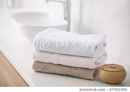 Stack of fresh towels on countertop in bathroom Stack of fresh towels on countertop in bathroom 87482400