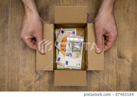 Euro banknotes in open box made from corrugated cardboard. Euro banknotes in open box made from corrugated cardboard. 87483184