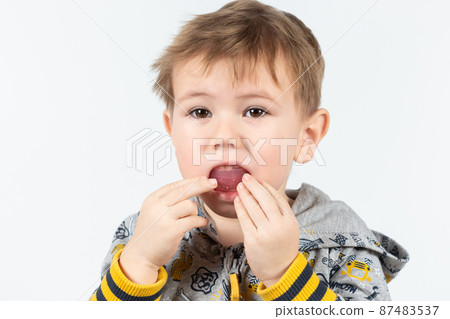 Adorable little child puts myofunctional trainer in the mouth. Adorable little child puts myofunctional trainer in the mouth. 87483537