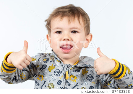 Cute little caucasian boy shows myofunctional trainer. Cute little caucasian boy shows myofunctional trainer. 87483538
