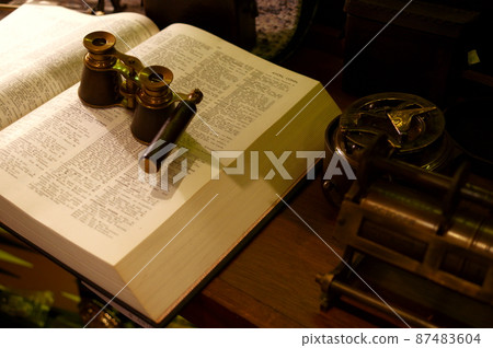 Blurred image of antique books and magnifying glass Blurred image of antique books and magnifying glass 87483604