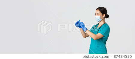 Covid-19, coronavirus disease, healthcare workers concept. Profile of asian female doctor, nurse in medical mask and globes, fill syringe with vaccine, doing vaccination shots, white background Covid-19, coronavirus disease, healthcare workers concept. Profile of asian female doctor, nurse in medical mask and globes, fill syringe with vaccine, doing vaccination shots, white background 87484550