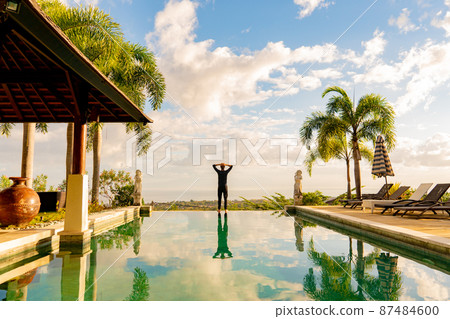 A man standing at the edge of infinity pool 87484600