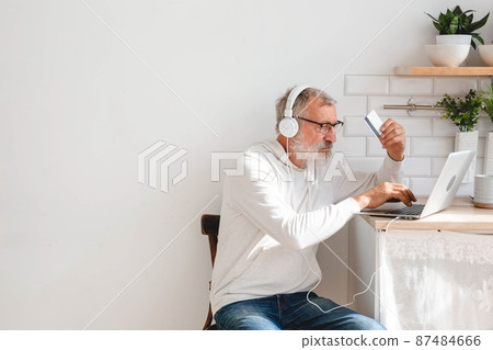 Senior elderly man making online payments using laptop. Old grandfather doing shopping ecommerce with credit card. Pensioner holding debit card for internet banking. Copy space and place advertising Senior elderly man making online payments using laptop. Old grandfather doing shopping ecommerce with credit card. Pensioner holding debit card for internet banking. Copy space and place advertising 87484666