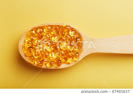 Vitamin D3 Capsules in a spoon with other vitamin D3 capsules around them on a yellow background Vitamin D3 Capsules in a spoon with other vitamin D3 capsules around them on a yellow background 87485637