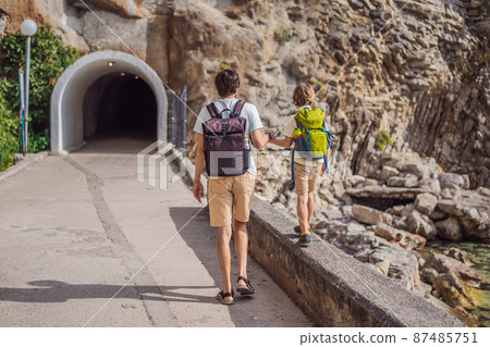 Dad and son tourists walks along the coast of Budva in Montenegro Dad and son tourists walks along the coast of Budva in Montenegro 87485751
