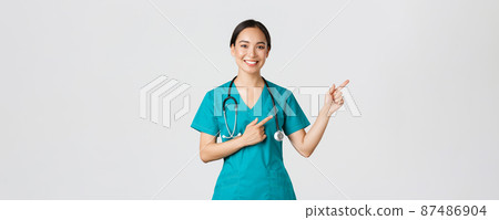 Covid-19, healthcare workers, pandemic concept. Smiling beautiful asian female nurse, intern pointing fingers upper right corner, inviting for checkup, online clinic appointment, white background Covid-19, healthcare workers, pandemic concept. Smiling beautiful asian female nurse, intern pointing fingers upper right corner, inviting for checkup, online clinic appointment, white background 87486904