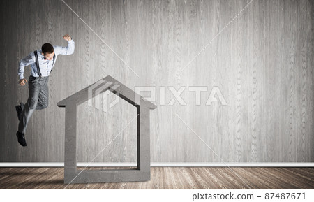 Stone home silhouette in empty room as symbol for real estate insurance 87487671