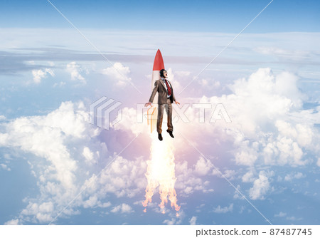 Business person in aviator hat flying on rocket Business person in aviator hat flying on rocket 87487745