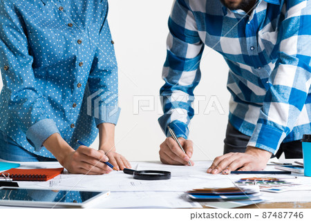 Man writing with pen on technical drawing Man writing with pen on technical drawing 87487746