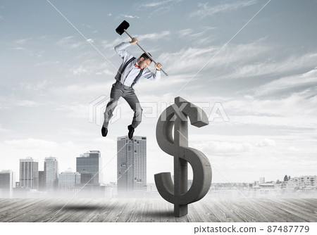 Determined banker man against modern cityscape breaking dollar concrete figure Determined banker man against modern cityscape breaking dollar concrete figure 87487779