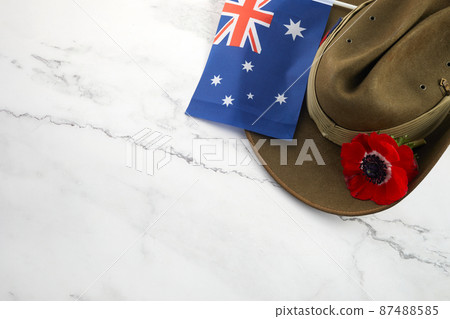 Anzac army slouch hat with Australian Flag and Poppy on stone background 87488585