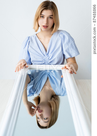 Fake emotion. Dual personality. Mood inversion. Portrait of confident flirting woman with shy modest pensive face mirror reflection isolated on white. 87488866