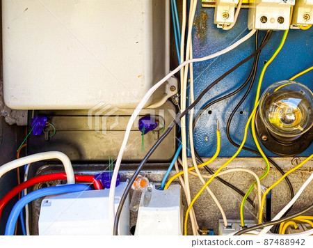 an electrical panel with many wires for conducting light to people's homes. homemade shield with a light bulb and sockets. current inside the box an electrical panel with many wires for conducting light to people's homes. homemade shield with a light bulb and sockets. current inside the box 87488942