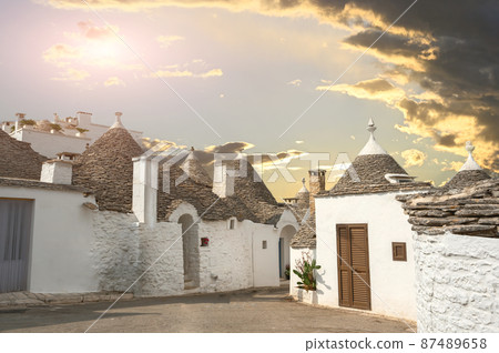 Alberobello, Puglia, Italy. August 2021. Amazing view at the golden hour on an alley of the historic village. Alberobello, Puglia, Italy. August 2021. Amazing view at the golden hour on an alley of the historic village. 87489658
