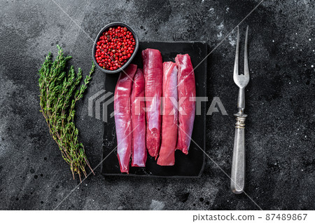 Fresh Raw lamb tenderloin Fillet, Mutton Sirloin Meat on marble board with thyme. Black background. Top view 87489867