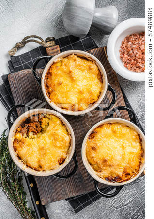 British dish Shepherd's pie with ground meat, mashed potato and cheddar cheese crust. White background. Top view British dish Shepherd's pie with ground meat, mashed potato and cheddar cheese crust. White background. Top view 87489883