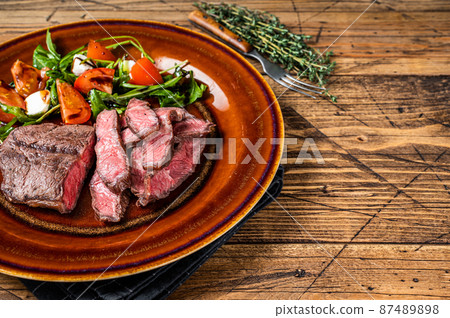 BBq roasted Oyster Top Blade or flat iron roast beef meat steak on a plate with salad. Wooden background. Top View. Copy space BBq roasted Oyster Top Blade or flat iron roast beef meat steak on a plate with salad. Wooden background. Top View. Copy space 87489898