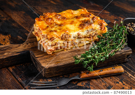 Italian Lasagna with bolognese sauce and mince beef meat. Dark Wooden background. Top view 87490013