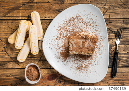Tiramisu Italian cake with cocoa in a plate. Wooden background. Top view 87490189