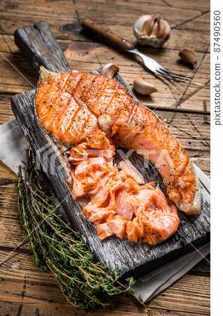 grilled Salmon Trout Fish Steak on a wooden board with herbs. Wooden background. Top view grilled Salmon Trout Fish Steak on a wooden board with herbs. Wooden background. Top view 87490560