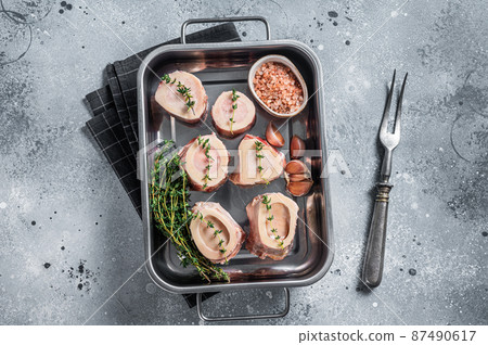 Raw beef Marrow bones in kitchen tray ready for cooking. Gray background. Top view 87490617