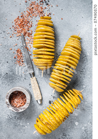 Uncooked raw Tornado or Twist potato fries. Wooden background. Top view. Copy space Uncooked raw Tornado or Twist potato fries. Wooden background. Top view. Copy space 87490870