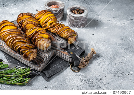 Crispy Tornado or twist potatoes chips on wooden board. Gray background. Top view. Copy space Crispy Tornado or twist potatoes chips on wooden board. Gray background. Top view. Copy space 87490907