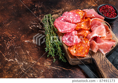 Spanish meat tapas - salami, jamon, choriso cured sausages. Dark background. Top view. Copy space 87491173