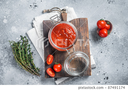 Homemade red tomato sauce with basil in glass jar. Gray background. Top view 87491174