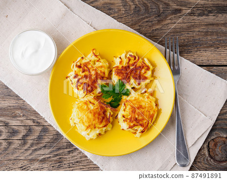 Crispy hashed browned potatoes on brown rustic background, top view. 87491891