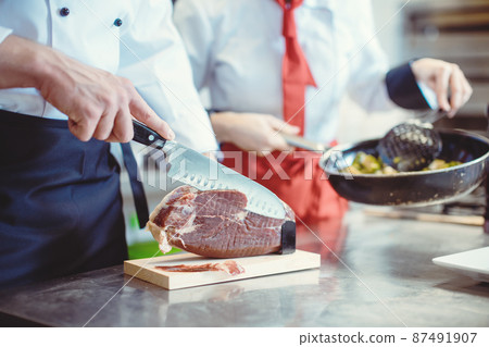 Detail shot of chef cook cutting Parma ham for use in a dish 87491907