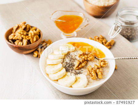 healthy breakfast - oatmeal with nuts, bananas, chia, mango , side view, close up healthy breakfast - oatmeal with nuts, bananas, chia, mango , side view, close up 87491927